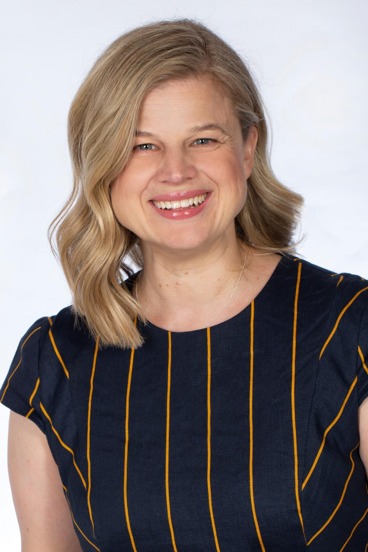 Emily smiling in a striped top
