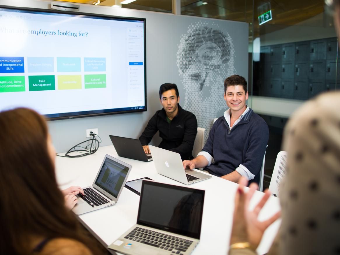 Three people sitting around computers