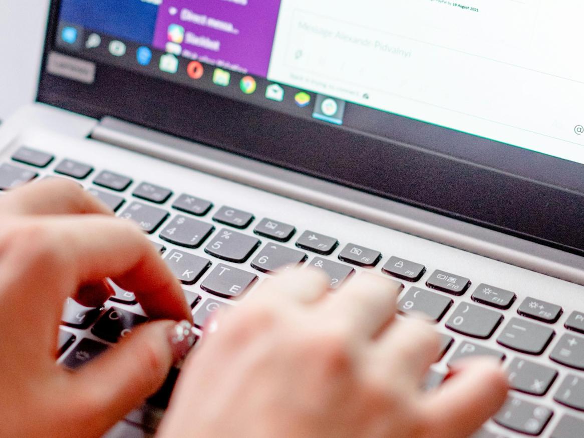 Hands typing on laptop