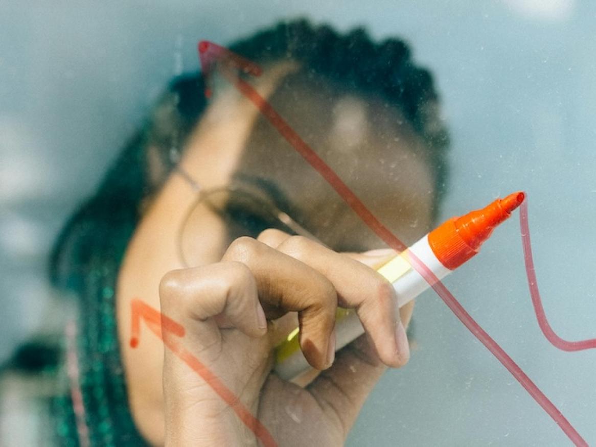 Women drawing on glass screen.