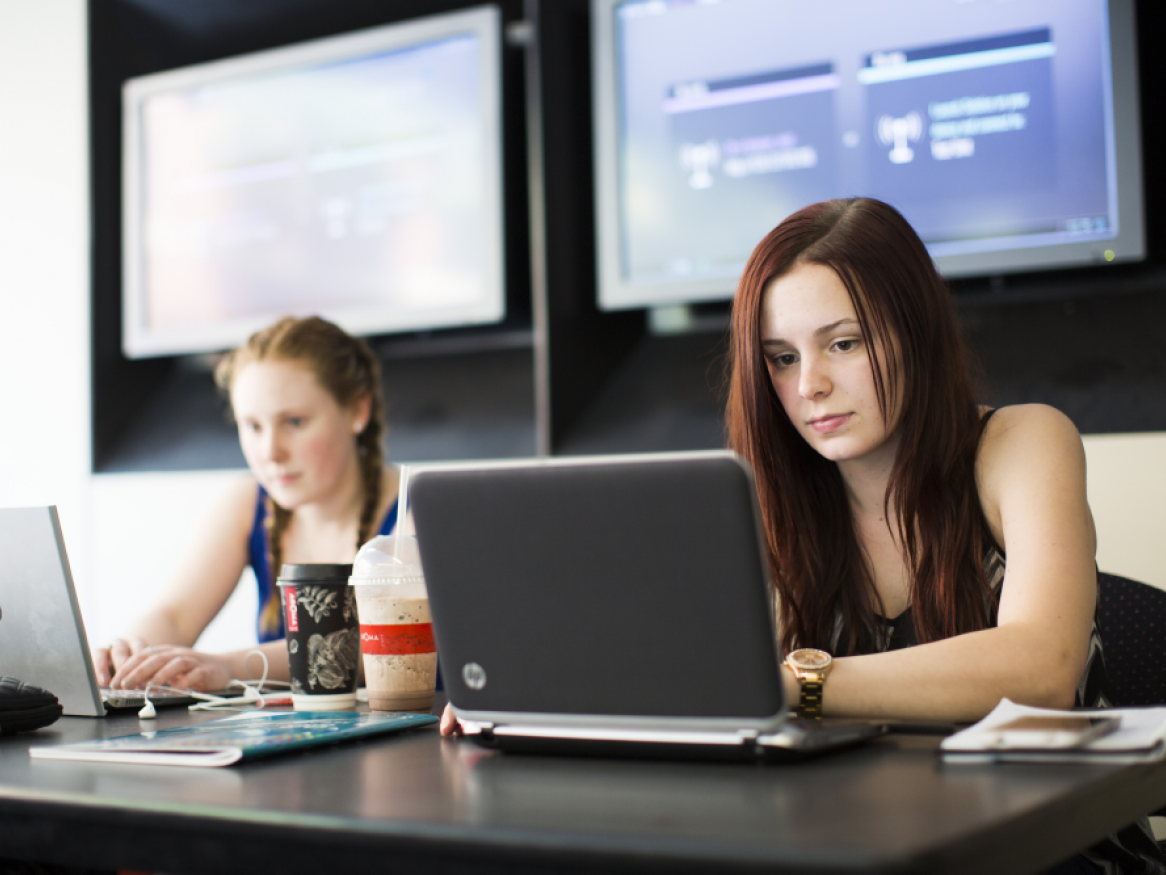 two people  typing on computer